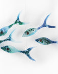 Five fused glass fish, handmade in coastal colours, creating an ocean inspired wall art display.