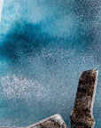Colour details on a fused glass tin mine wall panel set against a moody dark sky, creating a soft Cornish inspired piece of wall art.