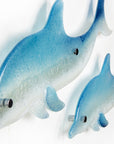 Two blue dolphin wall art panels, handmade i fused glass, designed in soft coastal blues and whites.