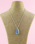 A Signature by Jo Downs fused glass pendant necklace, handmade using some of Jo's innovative techniques in soft botanical and ocean colours. Finished with a sterling silver chain and fittings, shown on a mannequin.