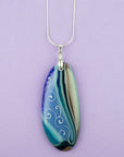 Fused glass pendant necklace, handmade in coastal hue, with an organic, swirling hand-painted design.