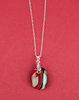 Fused glass pendant necklace, handmade in bright red hues, hung on a sterling silver chain.