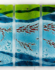 A fused glass triptych featuring marine blues and greens in an ocean design, with copper fish and textured detail.