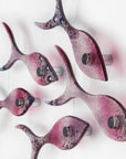 Side image of small fused glass wall display of individual handmade fish in rose pinks and bubbled purple hues.