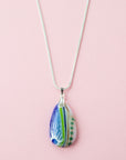 A Signature by Jo Downs fused glass pendant necklace, handmade using some of Jo's innovative techniques in soft botanical and ocean colours. Finished with a sterling silver chain and fittings.