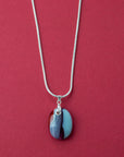 Artisan fused glass pendant necklace, handcrafted in our studio, with delicate blues and a flash of bright red. Finished with a sterling silver chain and fittings, a striking piece of wearable art
