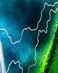 A detailed image of a fused glass wall panel in vibrant marine colours, in an abstract design. Hand-made in our Cornish studio.