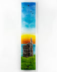 Fused glass wall panel, featuring a tin mine design, set against a vibrant sunrise in coastal colours.
