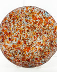 Fused glass round dish, handmade in vibrant recycled orange glass, creating a striking piece of art decor.