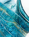 close-up of fold form fused glass vase textured blue teal