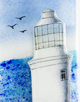 Close up of fused glass wall panel with lighthouse design and soaring seagulls. Handmade made in Cornish studio in coastal colours.