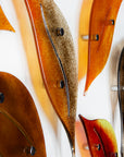 Close up of fused glass autumn leaf wall art display, in vibrant orange and natural browns.
