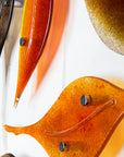 Details of fused glass autumn leaf wall art display, in vibrant orange and natural browns.