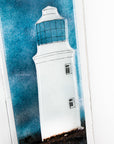 Close up of fused glass wall panel featuring a Cornish lighthouse design with a teal blue background and full moon design.