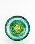 Fused glass round dish, featuring a dark emerald colour-way and a textured swirling detailing.