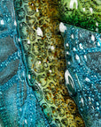 Intricate details of a hand-painted design of a sea turtle on a fused glass panel.
