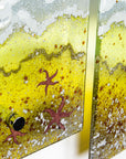 Copper starfish detailing on a fused glass triptych depicting a beach scene with blue water and texture.