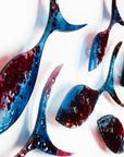 Detail of fused glass shoal of fish in a soft blue and textured burgundy colour-way.