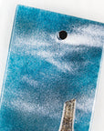 Details of small fused glass wall panel featuring a Cornish tin mine design, with a misty blue sky.