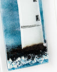 Textural detailing of small fused glass wall panel, featuring a lighthouse design in a teal blue colour-way.