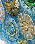 Close up of fused glass wall panel, designed with organic textural detail and aqua, marine blues.