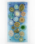Fused glass wall panel, designed with organic textural detail and aqua, marine blues.