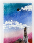 Details of small fused glass wall panel, featuring a tin mine design, with vibrant sunset sky.