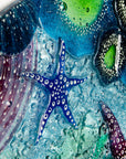 Close up of blue starfish on a fused glass extra large art frame, ocean reef inspired with coastal colours and texture.