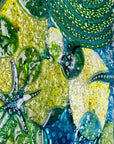 Textural detailing of round wall panel made from fused glass, inspired by the ocean reefs with starfish detailing and coastal colours.