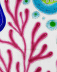 Close up of fused glass round dish, with hand painted design inspired by the ocean reefs in bright colours.