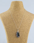 A fused glass pendant necklace, handmade in organic soft hues, hung on a sterling silver chain.