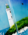 Close up of a lighthouse on a fused glass triptych in coastal colours, with distant soaring sea birds and a Cornish tin mine. Hand-made coastal wall art, with texture.