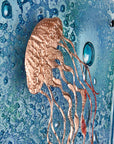 Detailing of fused glass staggered triptych, handmade using copper, which has been hand etched into an intricate Jellyfish design, with bubbled marine blue background.