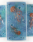 Fused glass staggered triptych, handmade using copper, which has been hand etched into an intricate Jellyfish design, with bubbled marine blue background.