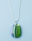 An artisan fused glass pendant necklace, handcrafted in our studio in soft coastal colours. Finished with a sterling silver chain and fittings, designed to be a striking piece of wearable art.