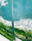 Close up of a fused glass triptych featuring a giant ocean wave, with aqua and sea green colours and white texture.