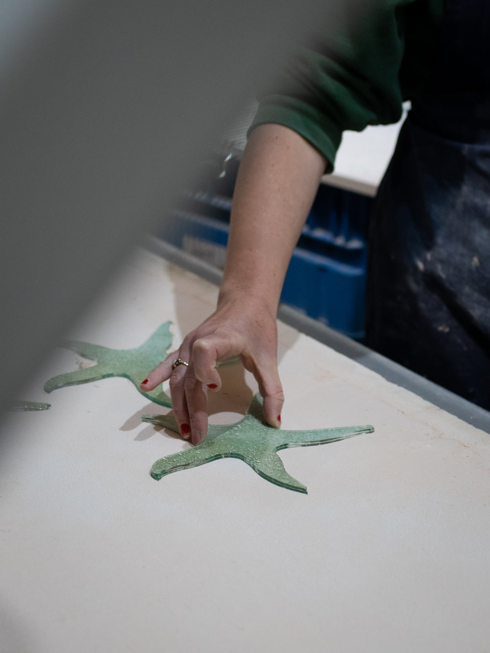 placing a fused glass starfish into the kiln before firing