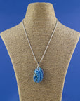 A signature by Jo Downs fused glass pendant necklace handmade using some of Jo's innovative techniques in rich ocean blues. Finished with a sterling silver chain and fittings, shown on a mannequin. 