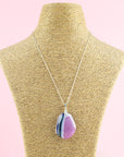 A fused glass pendant necklace handmade in rose pink hues, hung on a sterling silver chain. 
