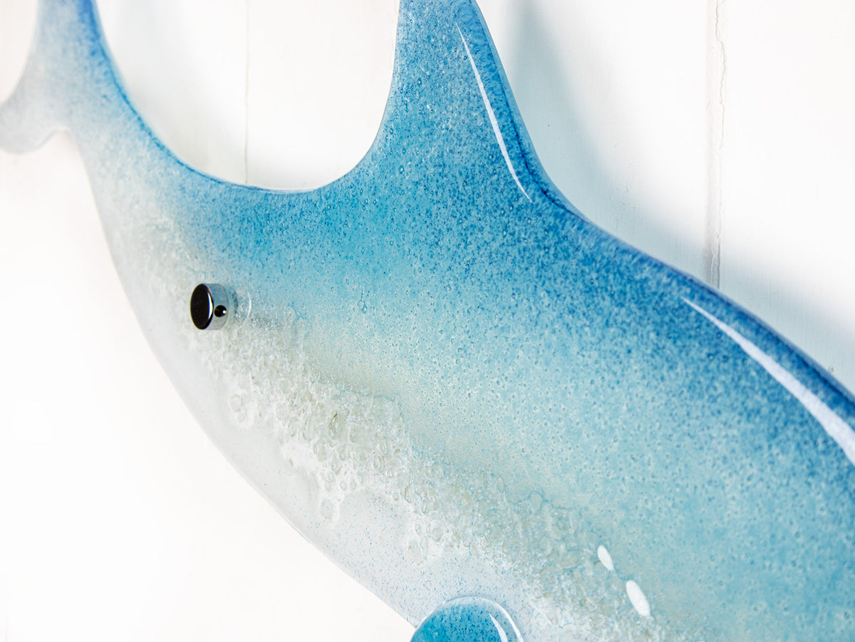 Details of a fused glass sculptural dolphin wall panel, handmade in soft and coastal aqua blue and white.
