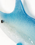 Details of a fused glass sculptural dolphin wall panel, handmade in soft and coastal aqua blue and white.
