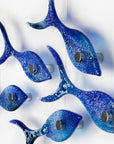 Close up of small fused glass shoal of fish, handmade in coastal blue colours with organic bubbled detailing. 