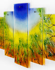 Fused glass quintych featuring an abstract design of a woodland, with a vibrant sunset sky and textured detailing. 