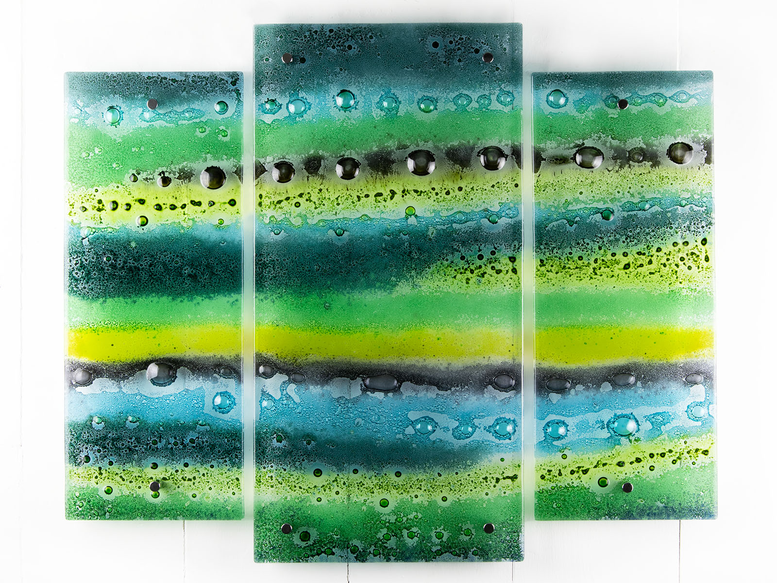 Fused glass triptych featuring an organic green design with bubbled detailing, handmade in emerald green colours. 