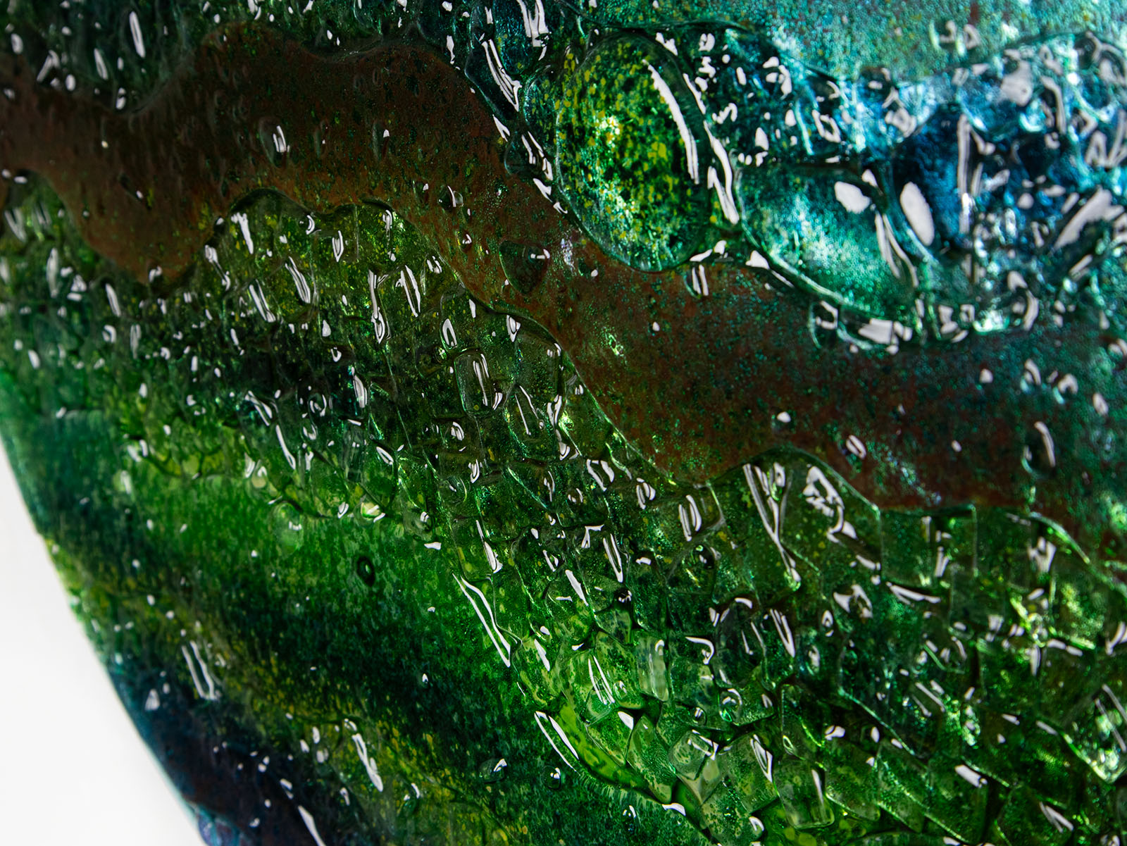 Details of a round textured glass wall art piece featuring an abstract design with wavy organic hues.