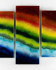 Fused glass staggered triptych in bright rainbow colours, placed onto mirror glass. A vibrant piece of wall art. 