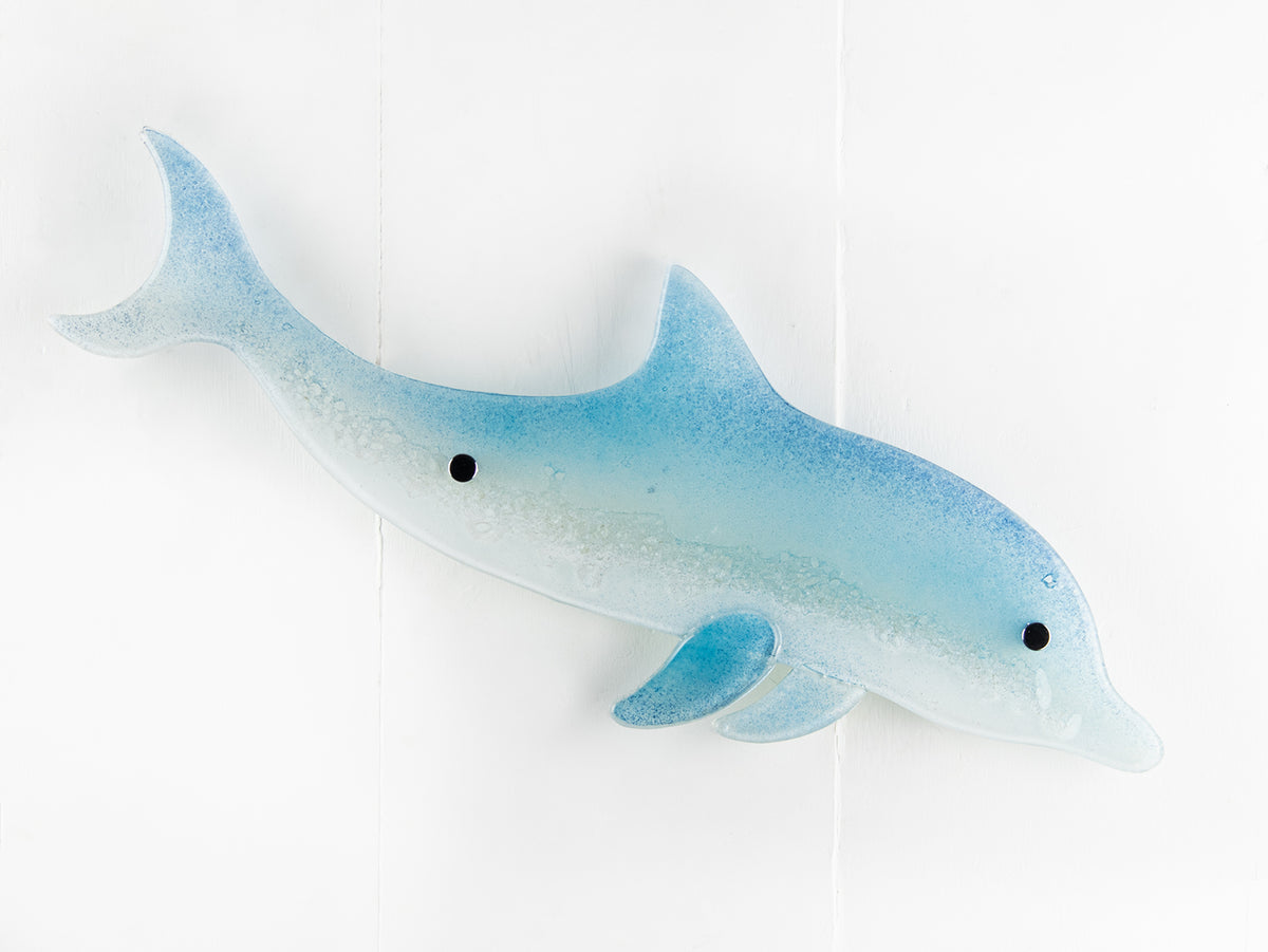 A fused glass sculptural dolphin wall panel, handmade in soft and coastal aqua blue and white.