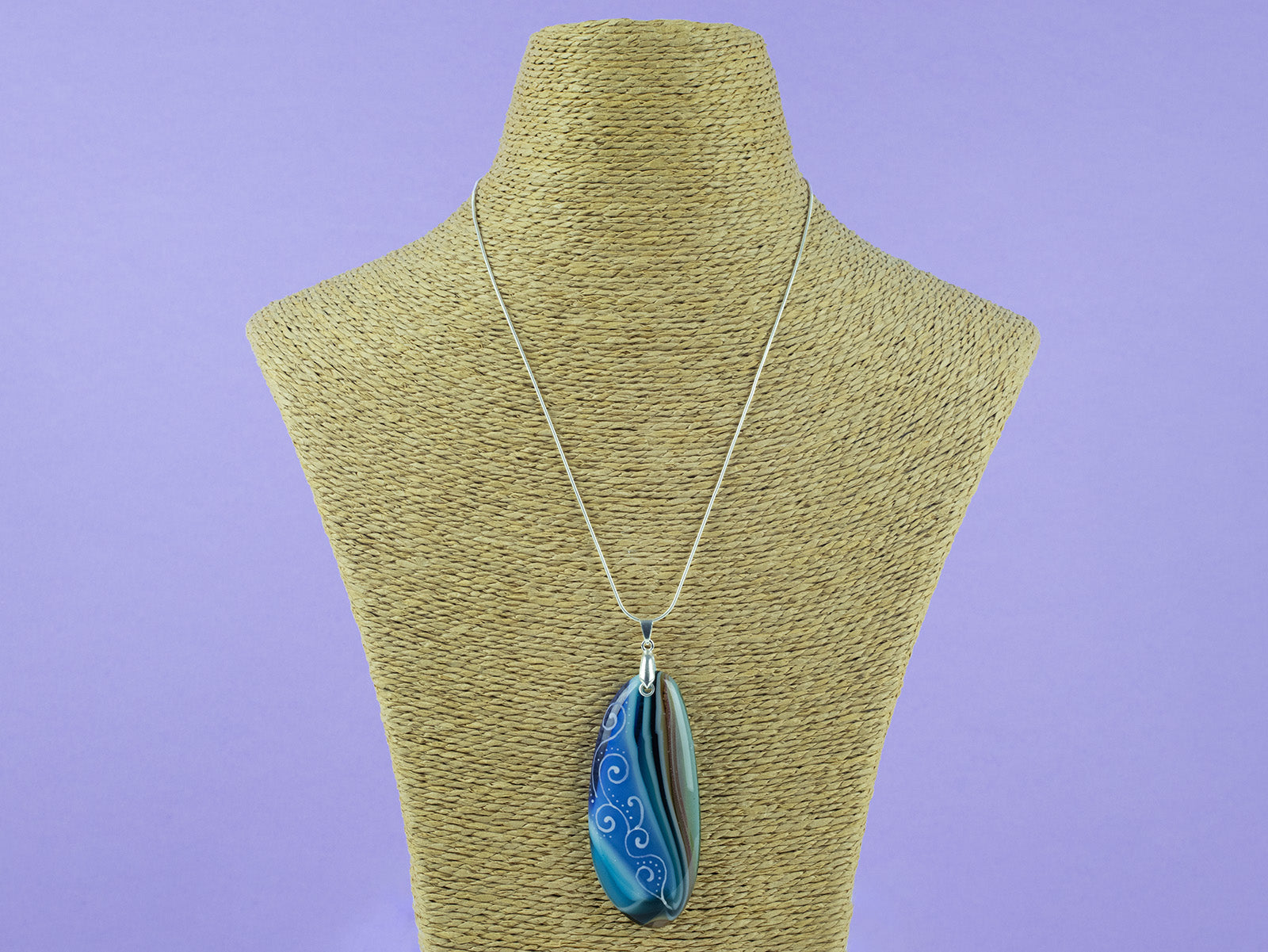 Fused glass pendant necklace, handmade in coastal hue, with an organic, swirling hand-painted design. Hung on a sterling silver chain. 