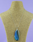 Fused glass pendant necklace, handmade in coastal hue, with an organic, swirling hand-painted design. Hung on a sterling silver chain. 