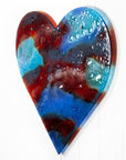 A striking 95cm fused glass hear shaped wall panel handcrafted in Cornish studio in bright reds, aqua blues and lots of textured detailing. 